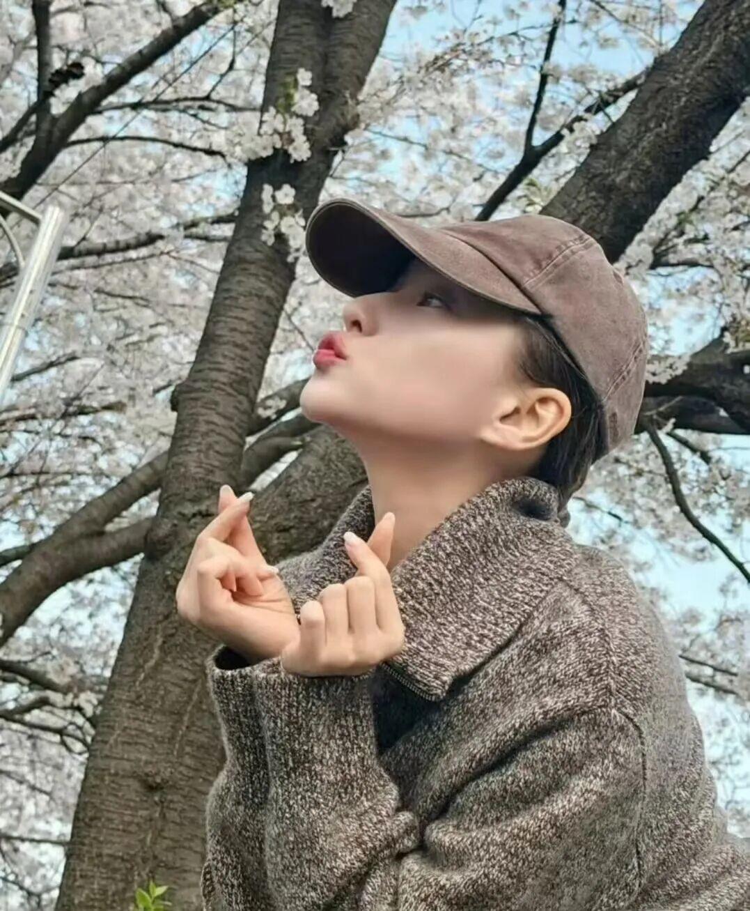 照片里的她，整个人透着一股子松弛感。
要么低头抿嘴笑，要么对着镜头比个心。
一看