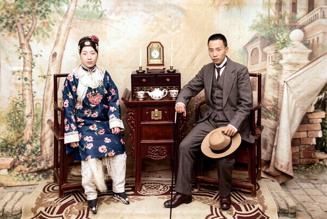 1920年，一对青年夫妇在照相馆内的合影。

丈夫一身笔挺西装，手执文明棍与礼帽