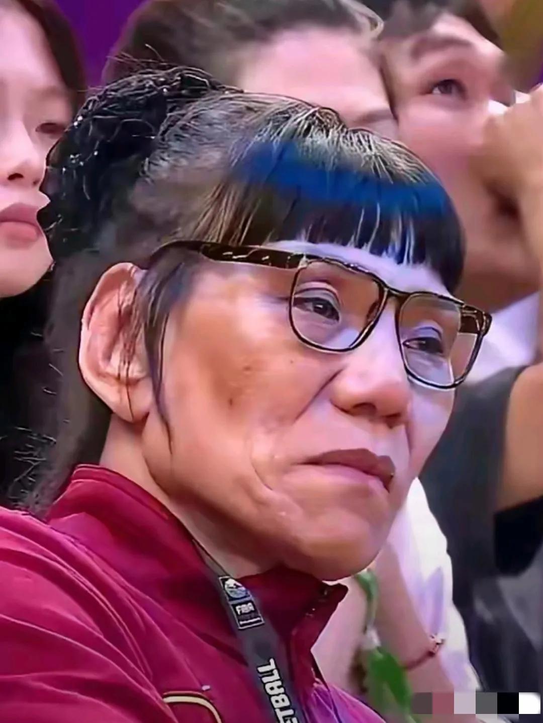 镜头中的郑海霞发型精致，柔发覆额，琼鼻高挺，面色偏黄，表情严峻，皱纹深刻，嘴角耷