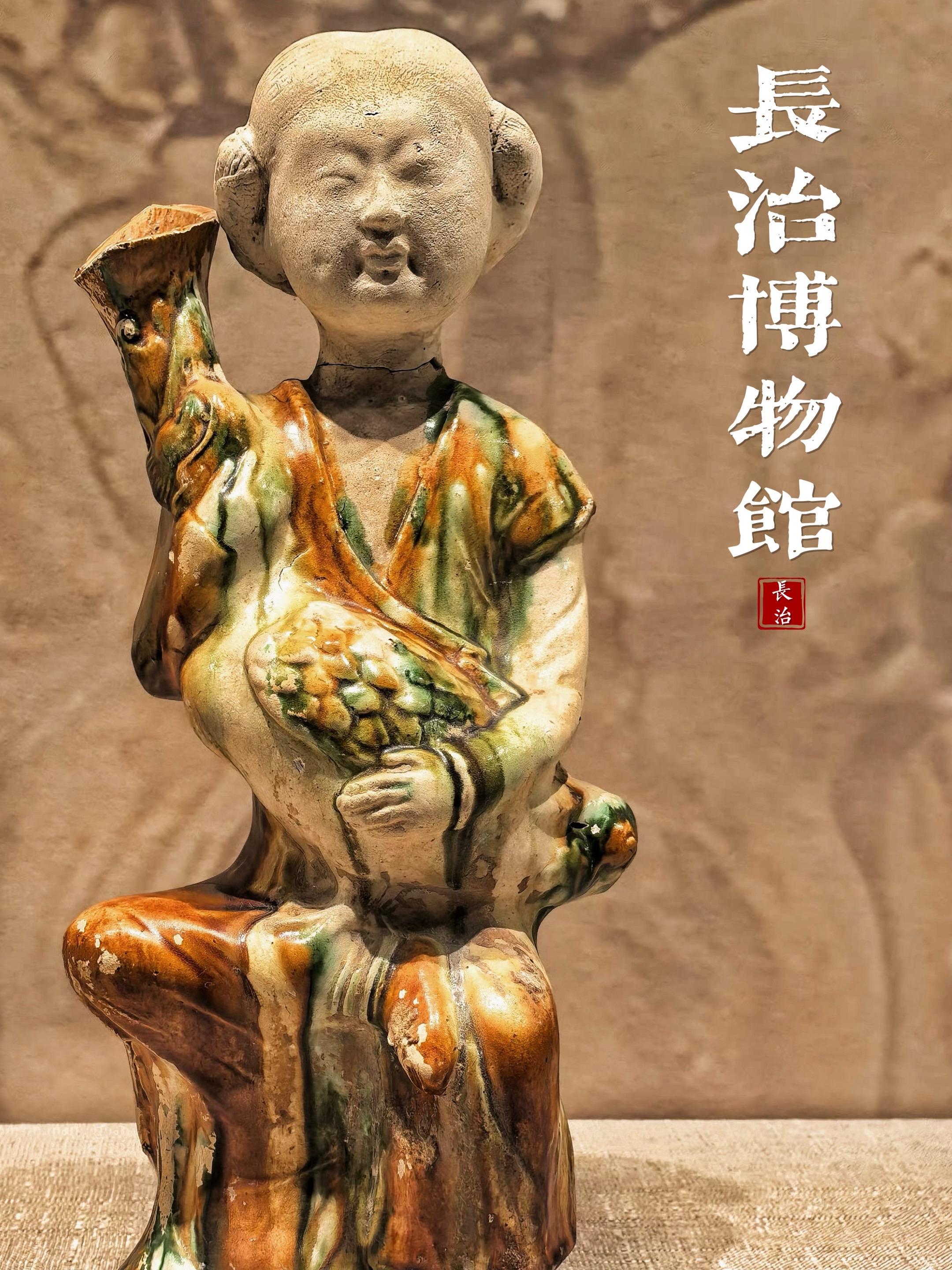 一位俏皮的小姑娘 嘴角含笑手里抱着的鸭形壶 一身窄袖胡服+传统襦裙的时...
