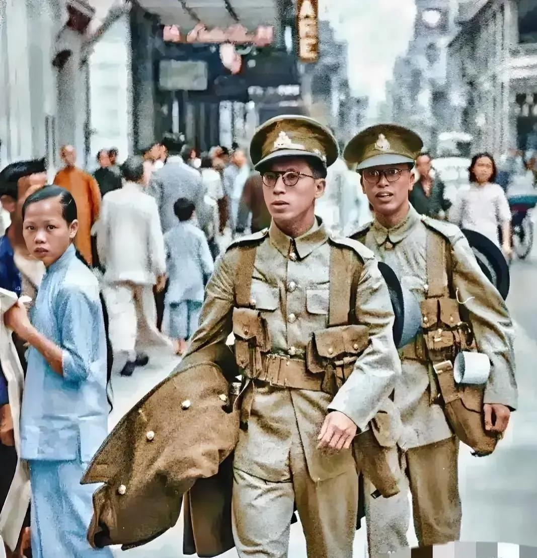 1946年，香港街头，两名身穿军装的警察正在巡逻，他们佩戴着眼镜，看上去很斯文，