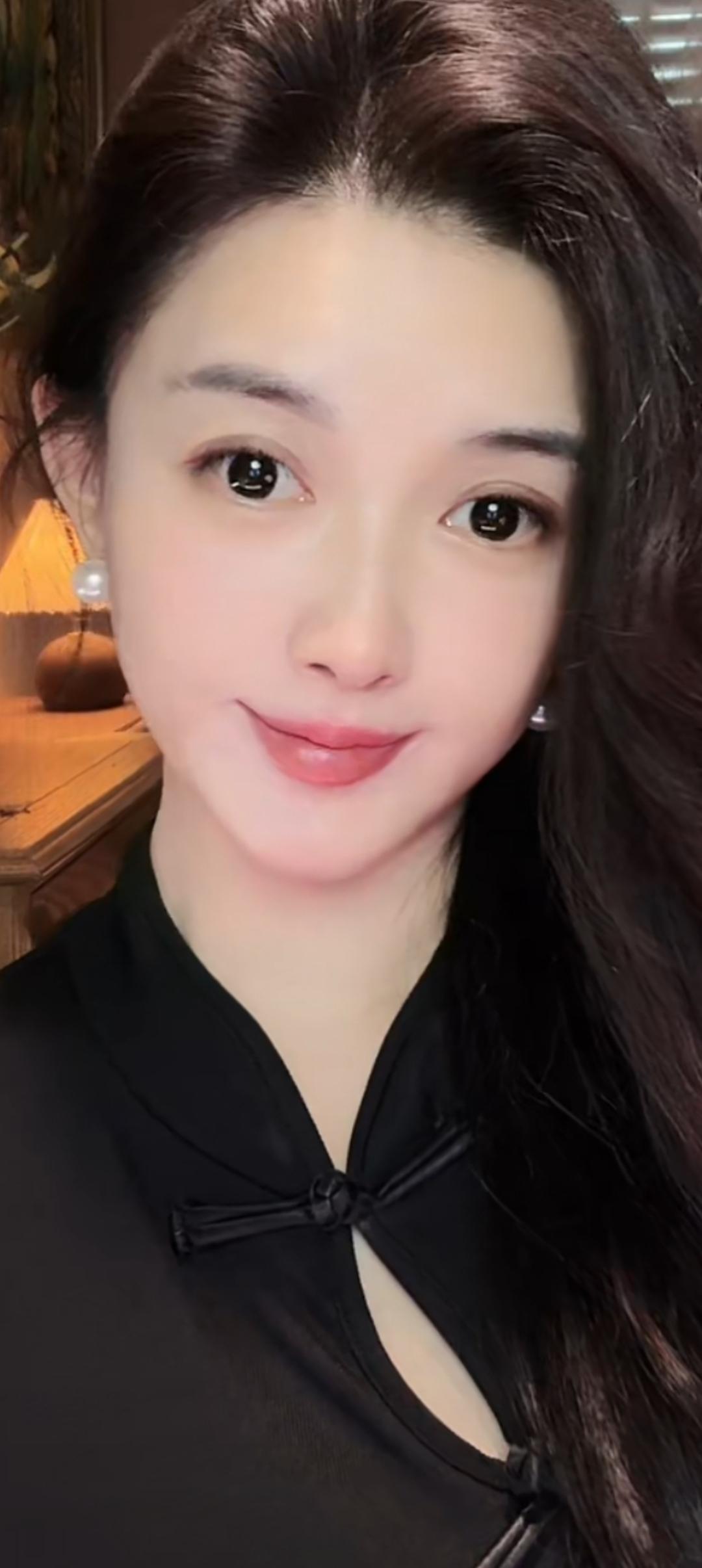 这位美女穿着黑色衣服，微笑着自拍。