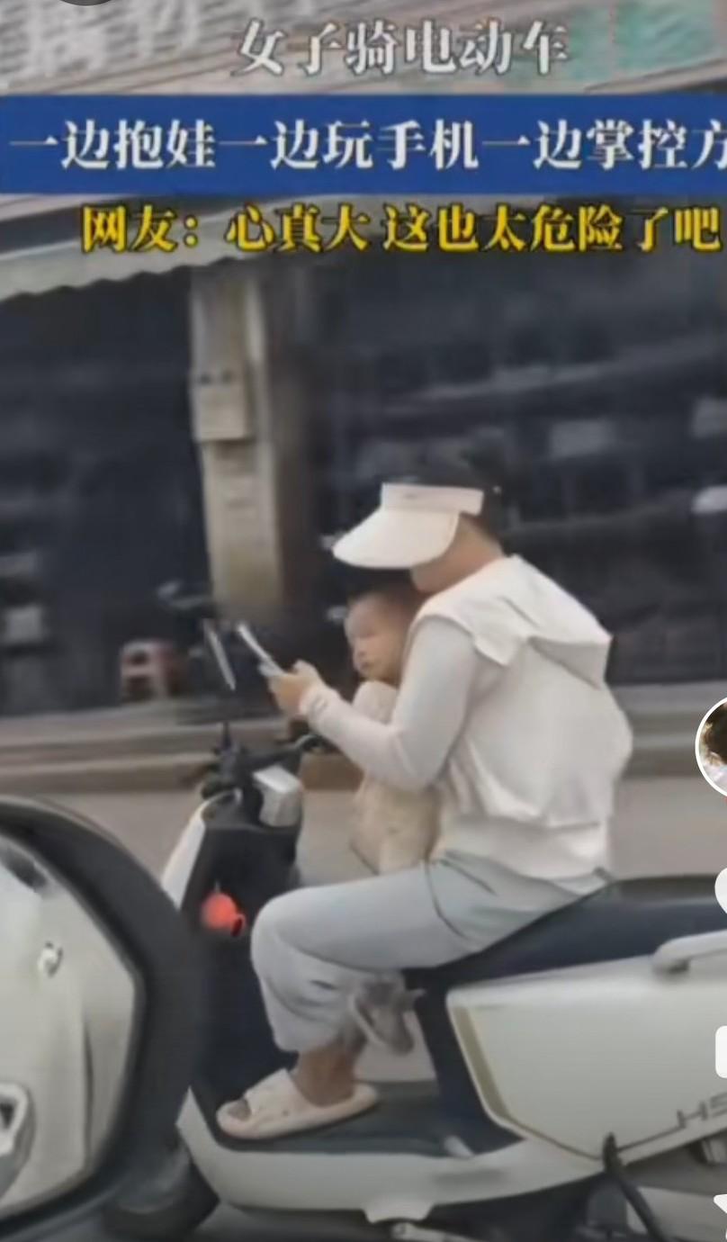 这位年轻妈妈可以去印度了。

她趿着拖鞋，骑着电动车，左手刷着手机，右手边掌握电
