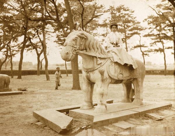 A woman posing on a stone horse at the T