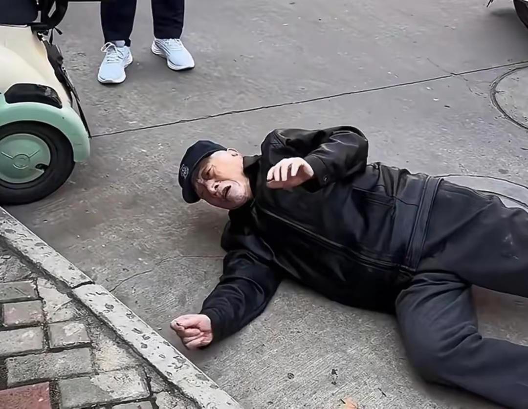 老人摔倒在地，想要借手机联系儿子，路人无人帮忙。两个女孩路过，只是帮忙打了110