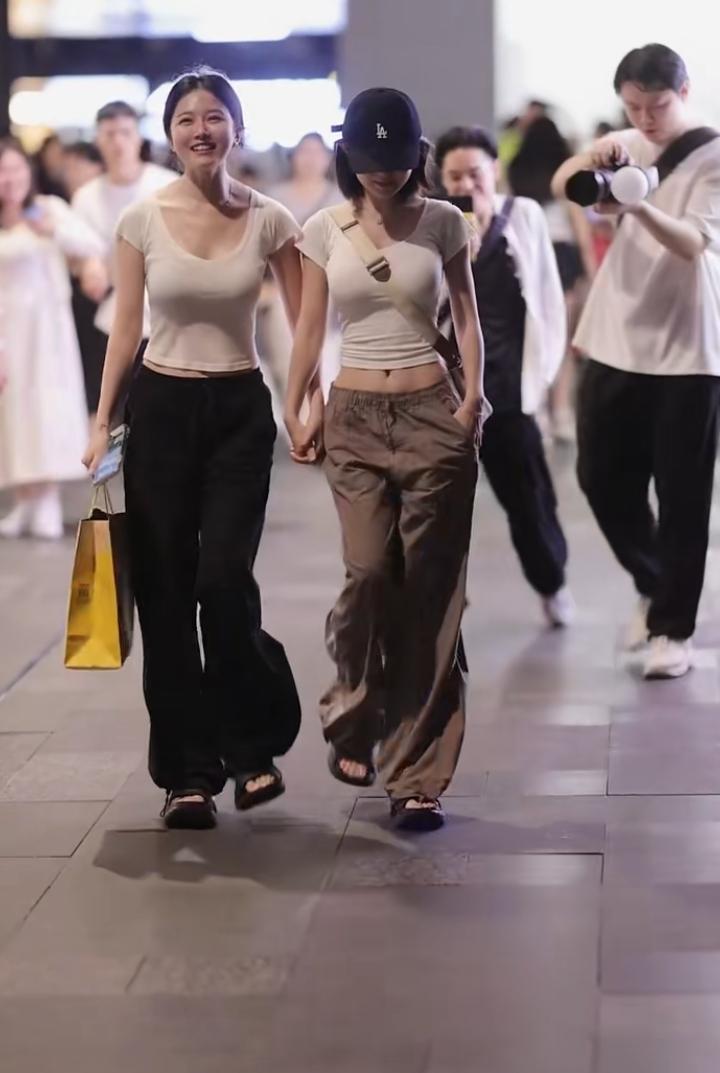 看到两位女生手牵手逛街开心走着，就想起甄子丹女儿甄济如和陈奕迅女儿陈康堤。她们手
