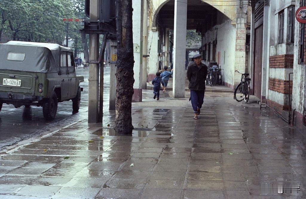 70年代，北京下起了濛濛细雨，一名男子从街头走过。马路边上，停着一辆军绿色吉普车