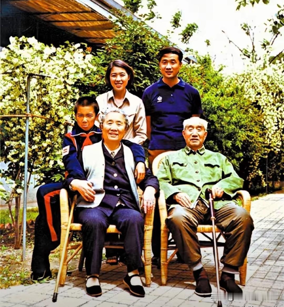 这是开国元帅徐向前的珍贵全家福。
庭院繁花掩映，徐向前身着绿色旧军装、拄拐端坐，