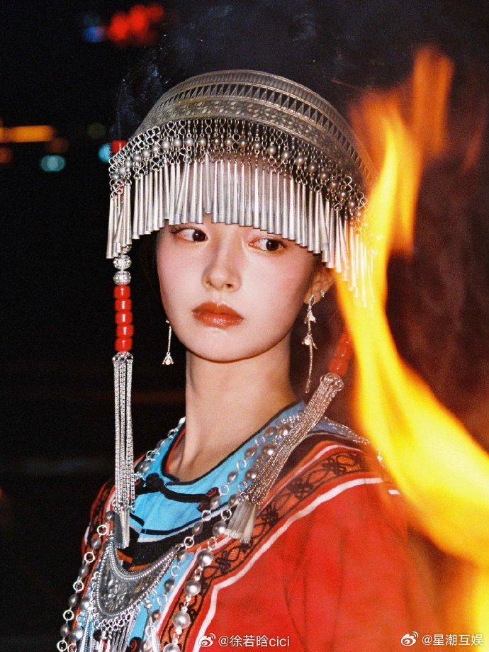 徐若晗篝火暮色大片 暮色四合，篝火明灭，她静静站在光影交界处。晚风裹挟着暖意，将