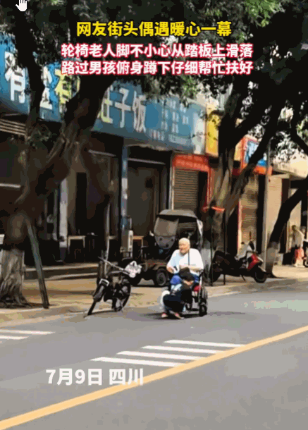 凡人善举暖人心！四川，人来人往的斑马线旁，一位轮椅老人的脚无力地从踏板滑落。一名