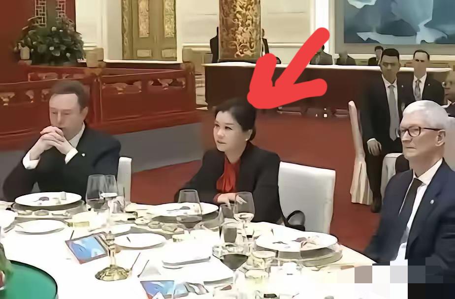 很多人好奇坐在马斯克和库克中间的女人是谁？她叫周群飞，1970年出生于湖南湘乡，