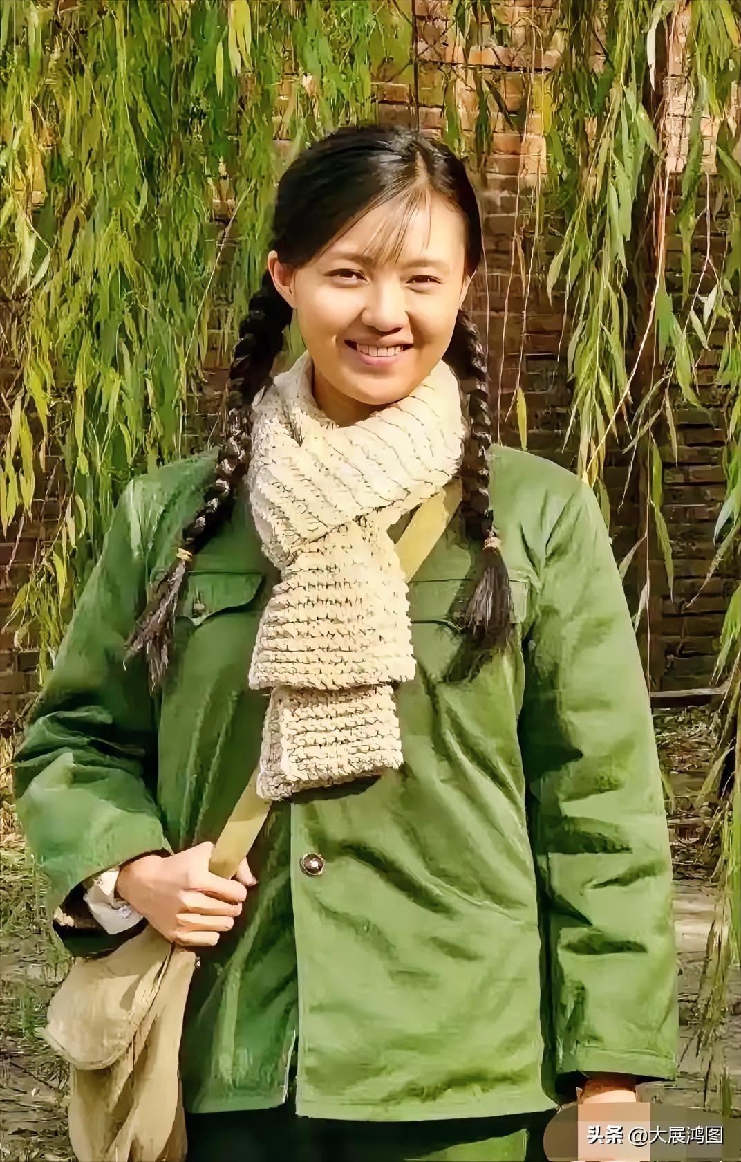 妹子穿着绿色大衣，微笑面对镜头。谁知道这美女是什么电视剧的剧照啊！评论区留言！