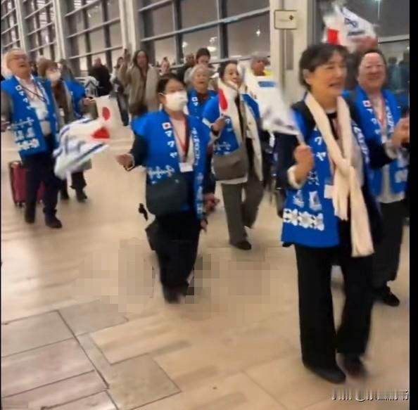 近日，一组日本游客抵达以色列，穿着统一的背心，挥舞着以色列和日本国旗，高声齐唱《