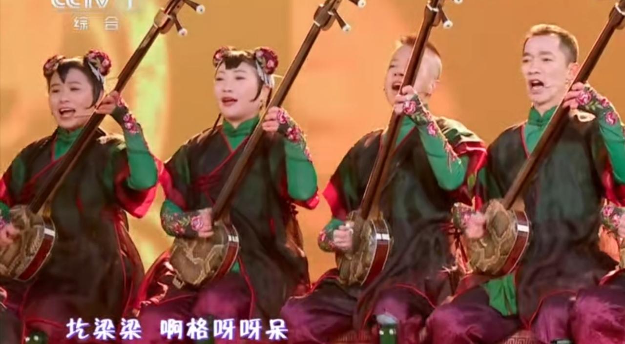 舞台上，表演者们手持三弦，身着红绿撞色的传统服饰，将华阴老腔的豪迈与鲜活展现得淋