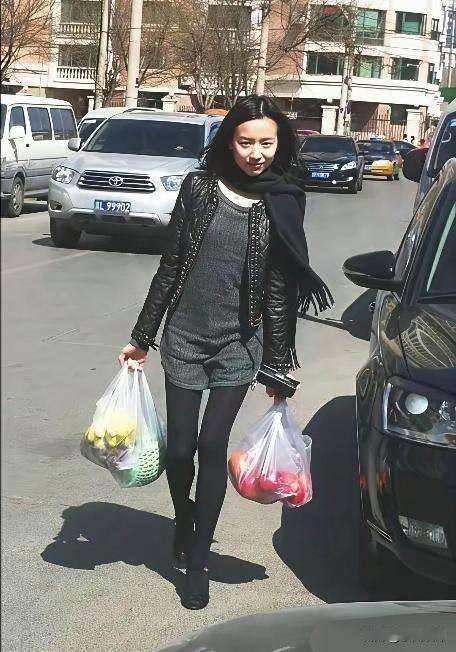 董洁的旧照，手上拎着两袋水果，特别接地气。很多人可能不知道，董洁最初是学舞蹈出身