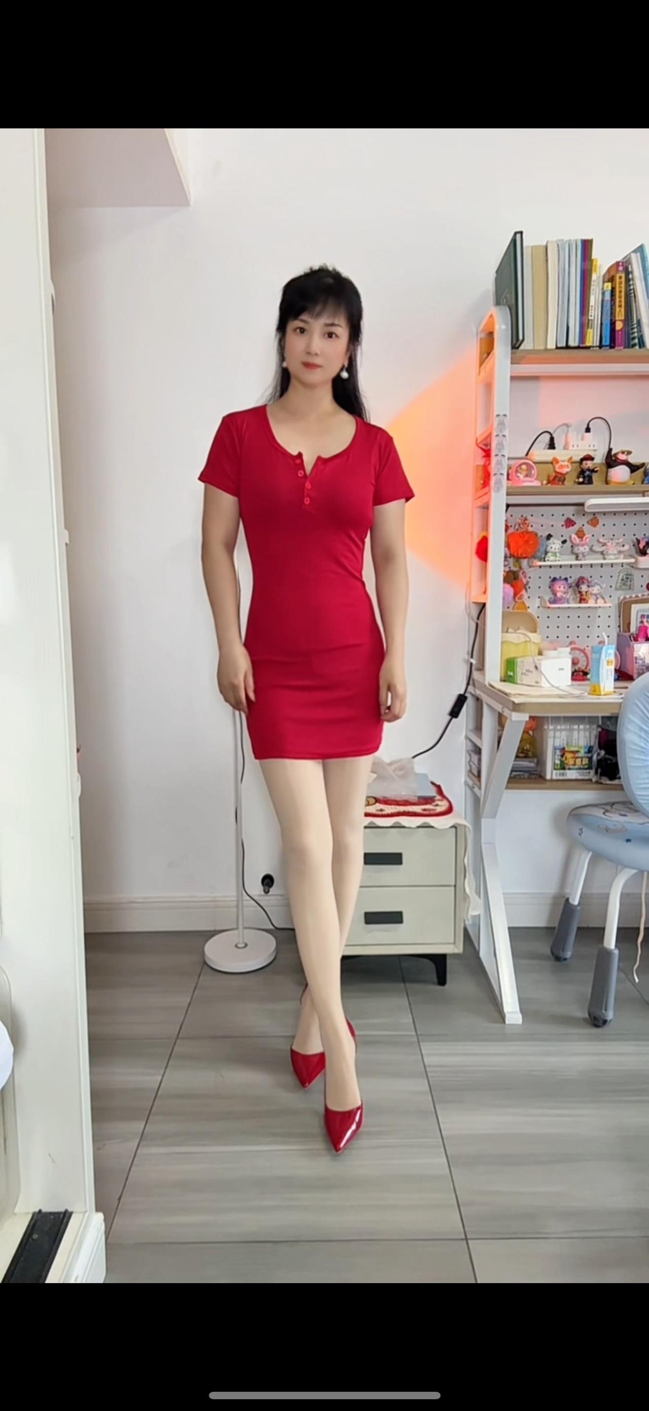 穿红色连衣裙的女士站在家中。