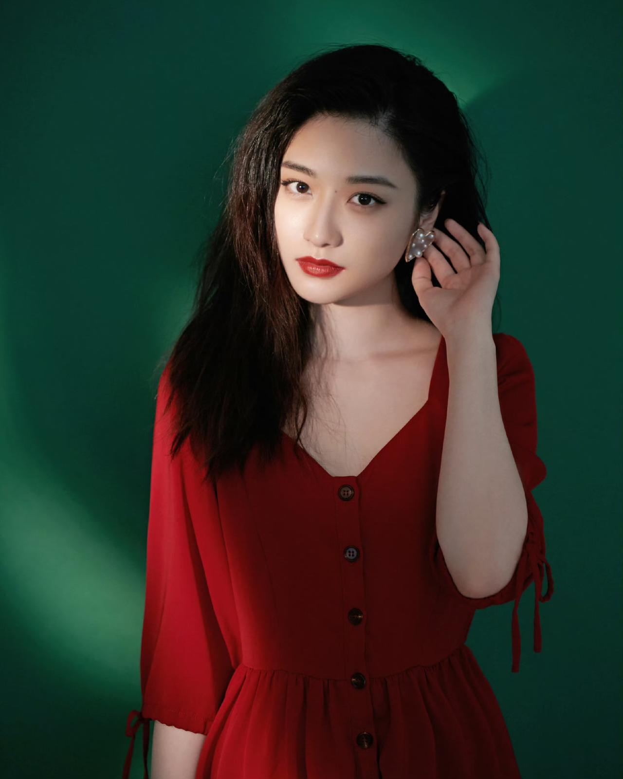 一抹浓烈的红，撞进深邃的绿里。光影落在侧脸，把温柔与热烈都揉进了镜头里。