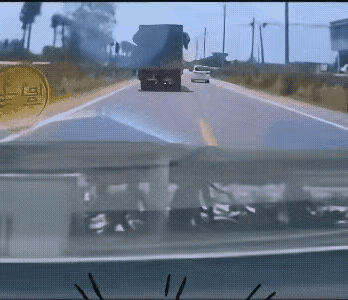 大货车超车，对向来车，情急之下大货车把白色小轿车撞到沟里，小轿车侧翻，大货车扬长