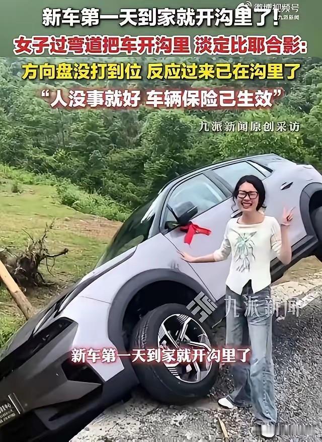 新车上路不到10分钟就栽进路边水沟，车头扎在泥里，车主却站在旁边笑着比耶。她说了