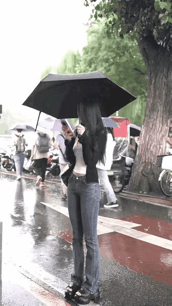 这个女孩引人注目，在这个下雨天，她成为一道风景，这其实就是一个非常普通的女子，但