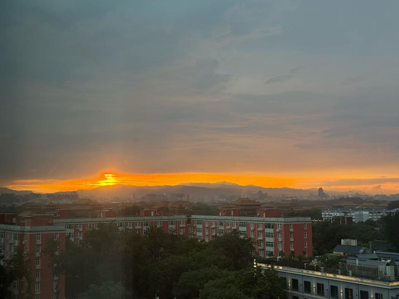 雨歇风柔，夕阳垂落北京城。水洗过后的天际澄澈透亮，霞光层层晕染，暮色缓缓笼罩大地