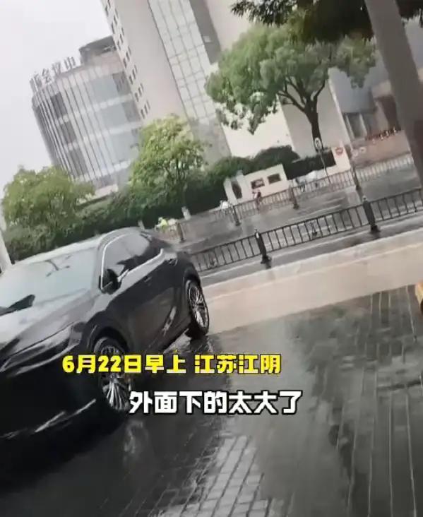 6月22日，江苏江阴突降暴雨，一名骑电动车的女子为避雨停靠在当地文体广旅局门口屋