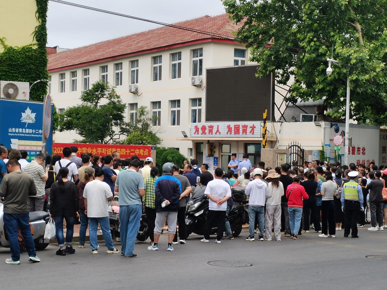 小区门口马路对面的42中学就是初中学业中考考点。考生家长们纷纷陪孩子来送考，之后