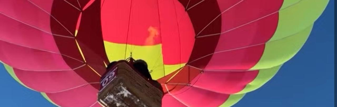 俄罗斯的雪原上空上演了一场浪漫又震撼的热气球盛宴，五彩斑斓的热气球群在皑皑白雪映