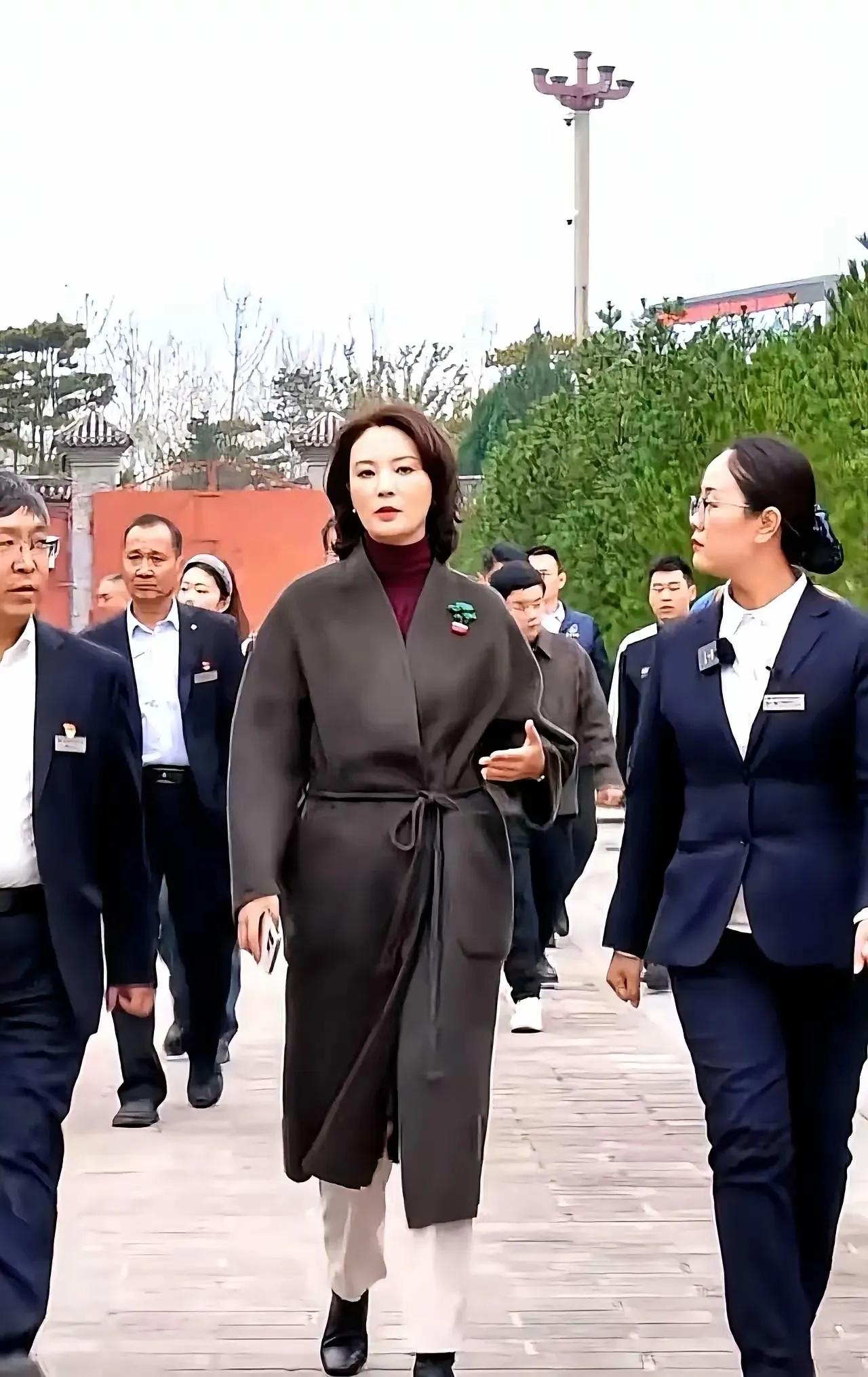 图片上这些人物，无论是前面这个女性，还是后面那些人群，纯粹都是AI合成的，根本不