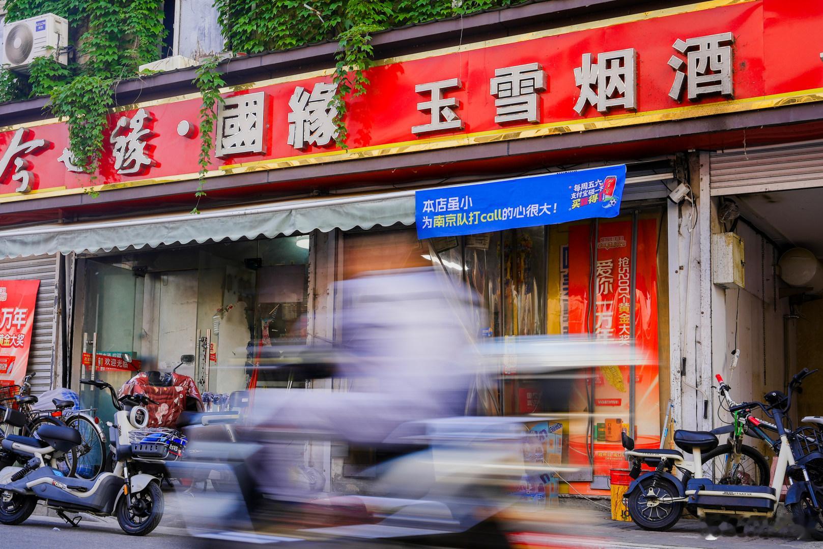 百店发支付宝助威袋为南京队加油支付宝疯狂碰友日走在南京街头，连大大小小的便利店都