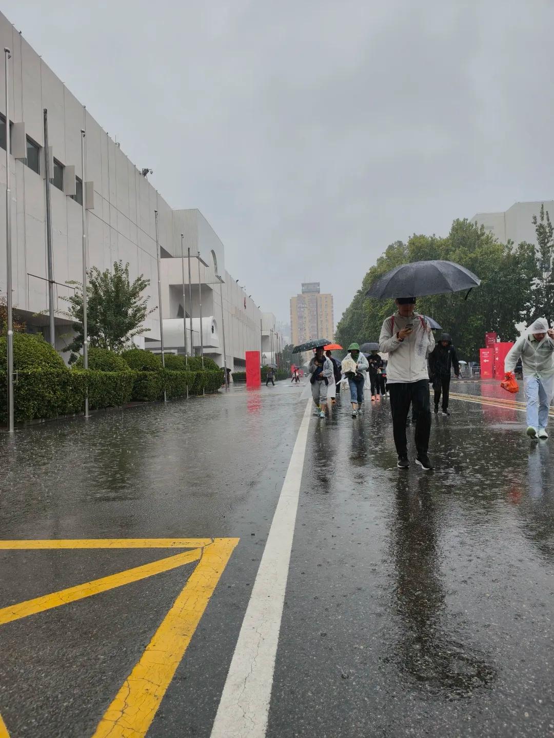 国马北马领物现场遇暴雨，引发跑友热议。
排队区域没有雨棚，大雨积水，跑者冒雨长时