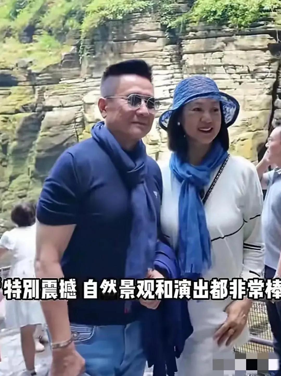 70岁的张志坚携69岁的妻子外出游玩，夫妻俩胖瘦适宜，系同色纱巾，衣着时尚，状态
