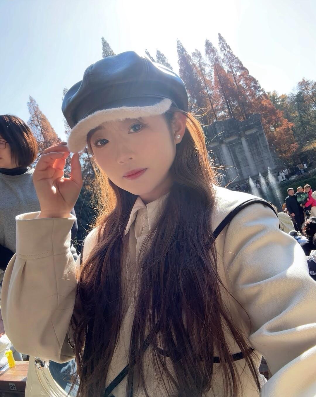 秋日暖阳下，少女帽檐轻抚，岁月静好。