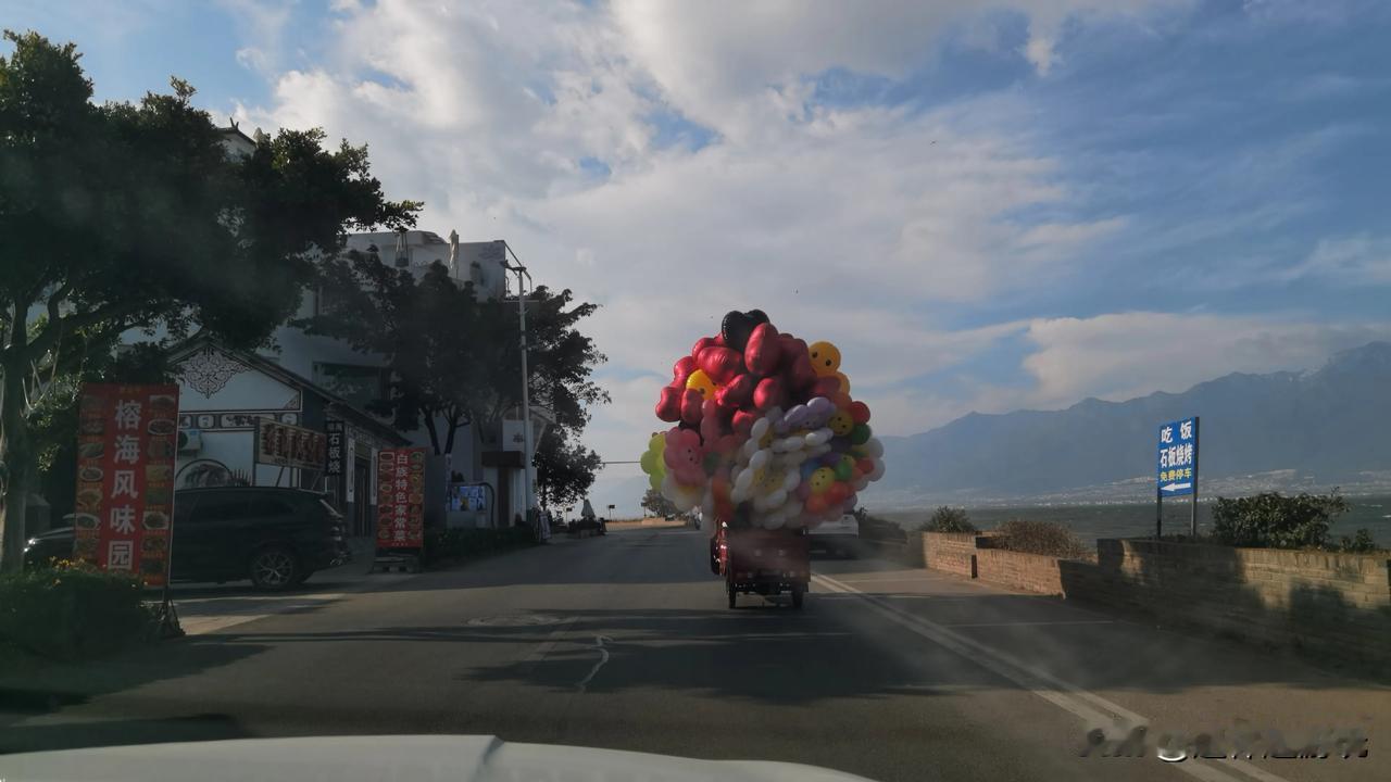 自驾环洱海游，途中遇见一辆装满彩色气球的小车，蓝天白云下格外耀眼，也感觉格外美，