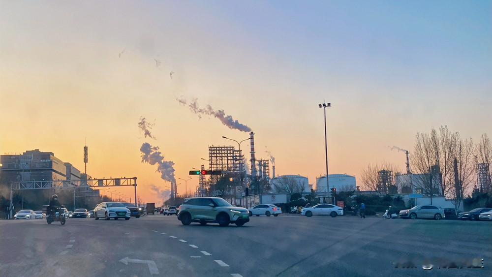 远处这个炼油厂，已经被城市包围了。

袅袅炊烟，大烟筒，
这种白色烟是什么成分？
