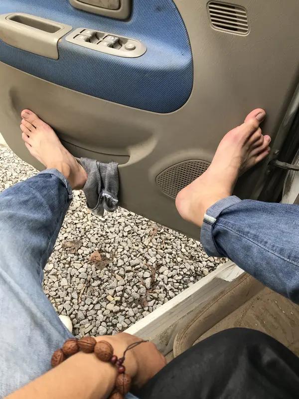 客运车辆行驶途中，后排男子脱鞋将光脚搭在前排座椅靠背，脚部贴近前排女乘客头部位置