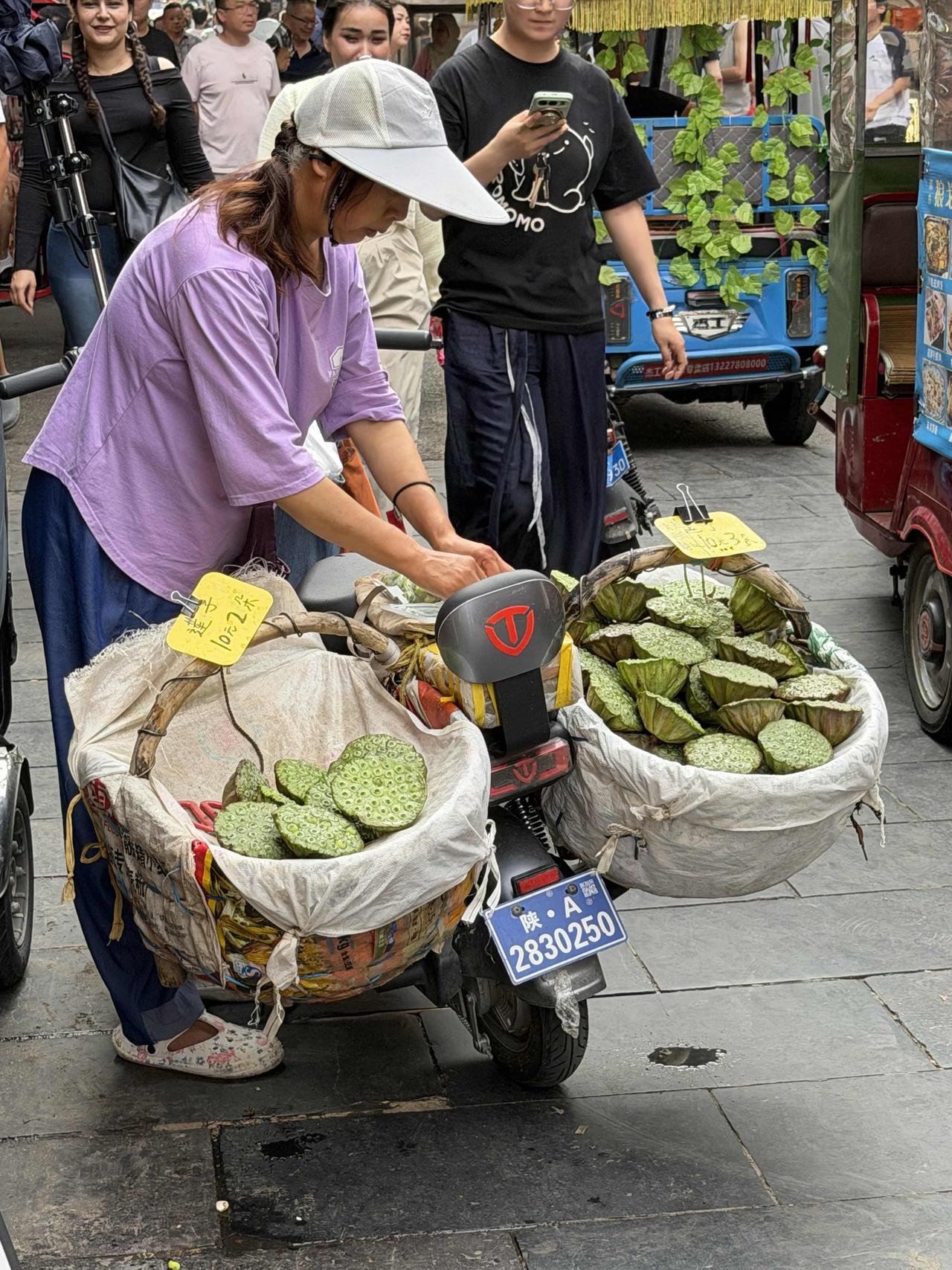 上周，我经过西安回坊的西羊市，走到西口时，看到有位农村大姐，在售卖新鲜的莲子！