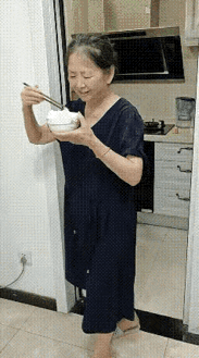 这是一个好婆婆，她把饭做好全部端在桌子上，儿媳妇和孙子开心地吃着饭，等她端着一碗