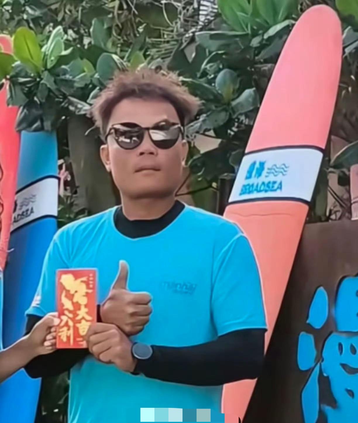 海南万宁一幼童被海浪卷入海中，图中的 00 后冲浪教练挺身而出，持冲浪板把小孩从