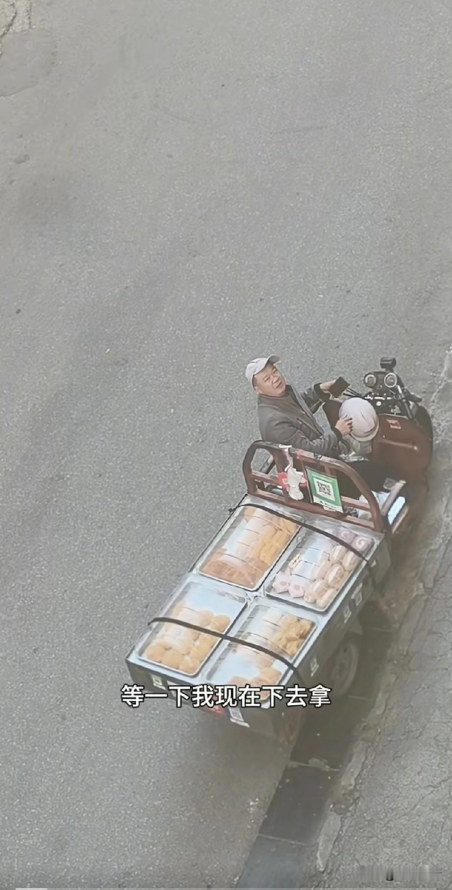 这位卖面包的大叔火了，
他骑着自己的三轮车卖面包，
被一个楼上的女孩叫住了，
女