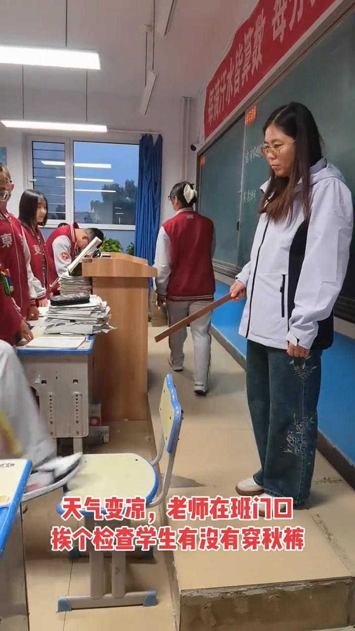 天气变凉，老师在班门口挨个检查学生有没有穿秋裤。