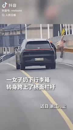 心酸又泪目。一位女子拉着行李箱经过一座大桥时，扔下行李箱，转身就决绝地爬上桥面轻