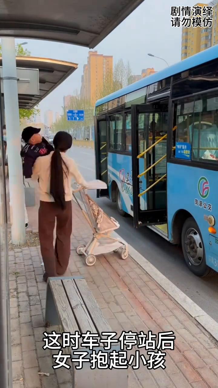 女子推着婴儿车在等公交车，下一秒男乘客很热心的帮助她。
女子推着婴儿车在等公交车