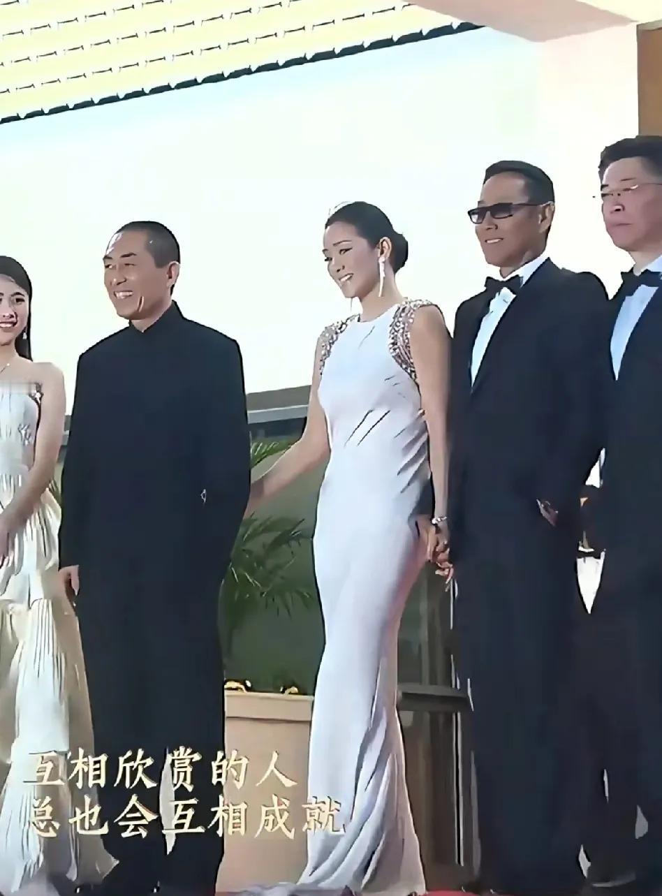 在电影节走红毯环节巩俐和陈道明手挽手走在最前排，张艺谋像个小弟一样帮巩俐提裙子，