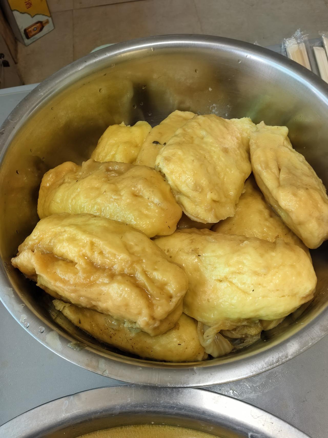 这盆大饼子是贴在炖鱼的大铁锅里的，等到鱼咕嘟好了，大饼子也吸满了汤汁，很香。
