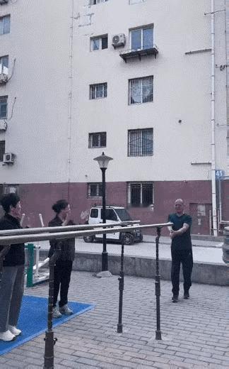 老者双杠健身，一上来把身体前后悠了起来，让人看起来身轻如燕，几位大妈对他哗哗鼓掌