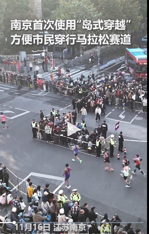 “这招好！”南京首次使用“岛式穿越”方便市民穿行马拉松赛道，比赛期间，交警在路边