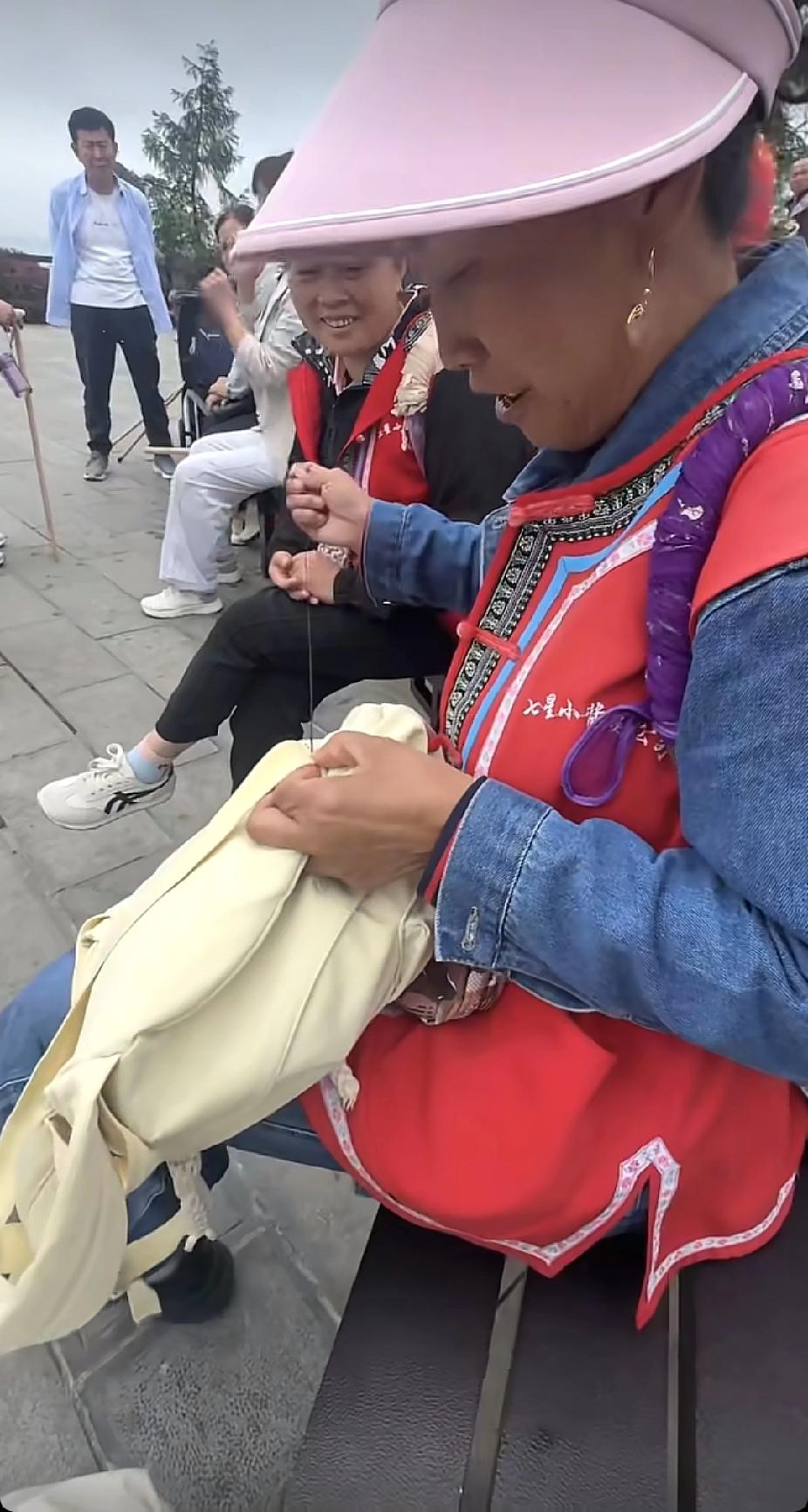 正在景区游玩的年轻女子，背包背带突然坏了，陌生孃孃的一个举动，让女子直呼感动了。
