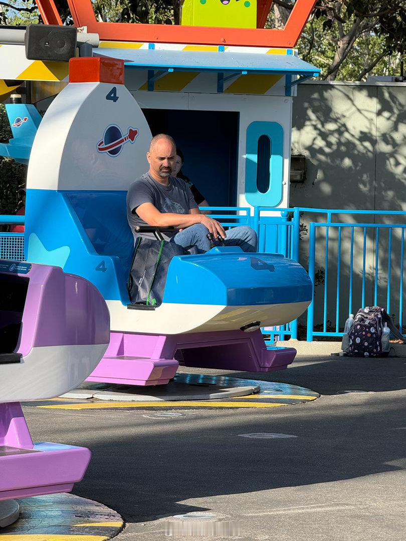 小孩坐的升降旋转小飞机，或者父母陪着娃一起坐。看到对面有个中年大哥，一个人坐在小