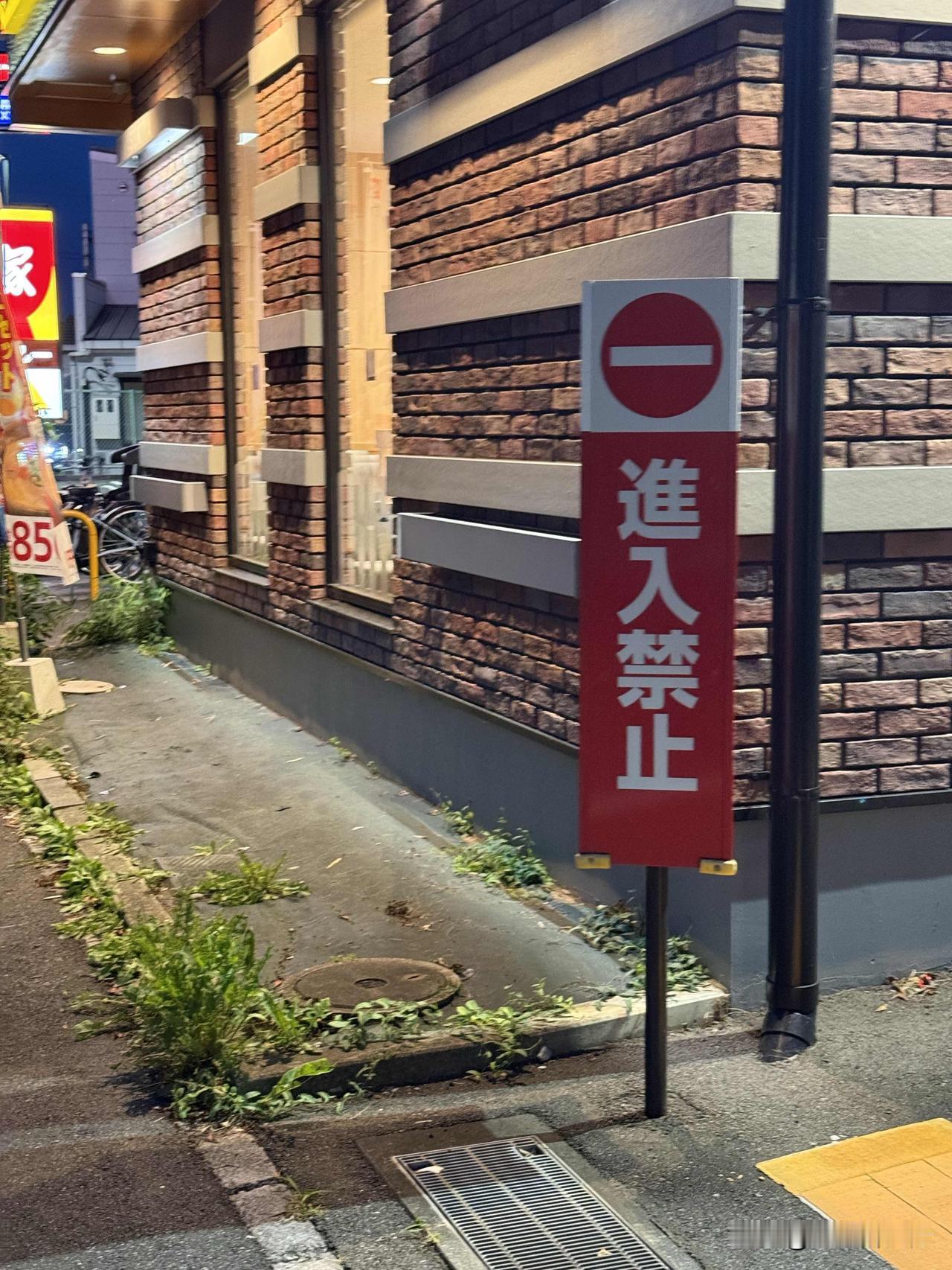 日元不用学也能知道大概意思吧。看这店铺外的标牌：进入禁止。
这一看就懂，就是驾车